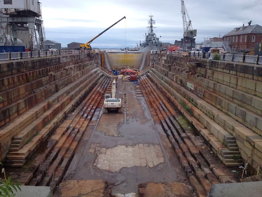 Cranes at work inside dry dock staging area for a very large boat